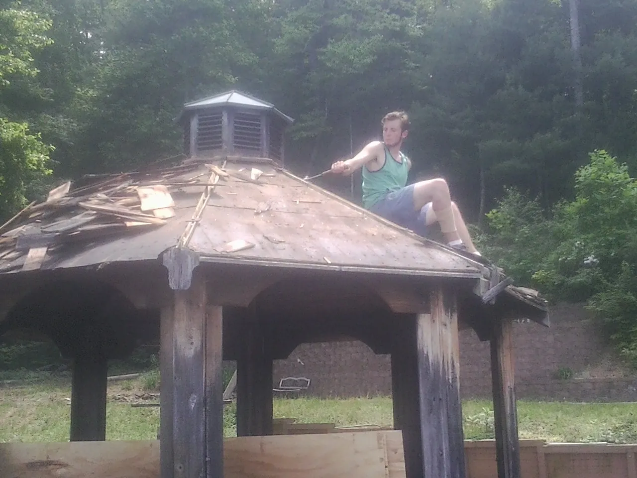 Tearing the old roof off a wooden gazebo before new shakes in Carversville