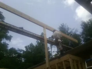 Carpenter setting a ridge beam over a new addition frame — Ice Dam Removal by Roofing Brothers in Carversville