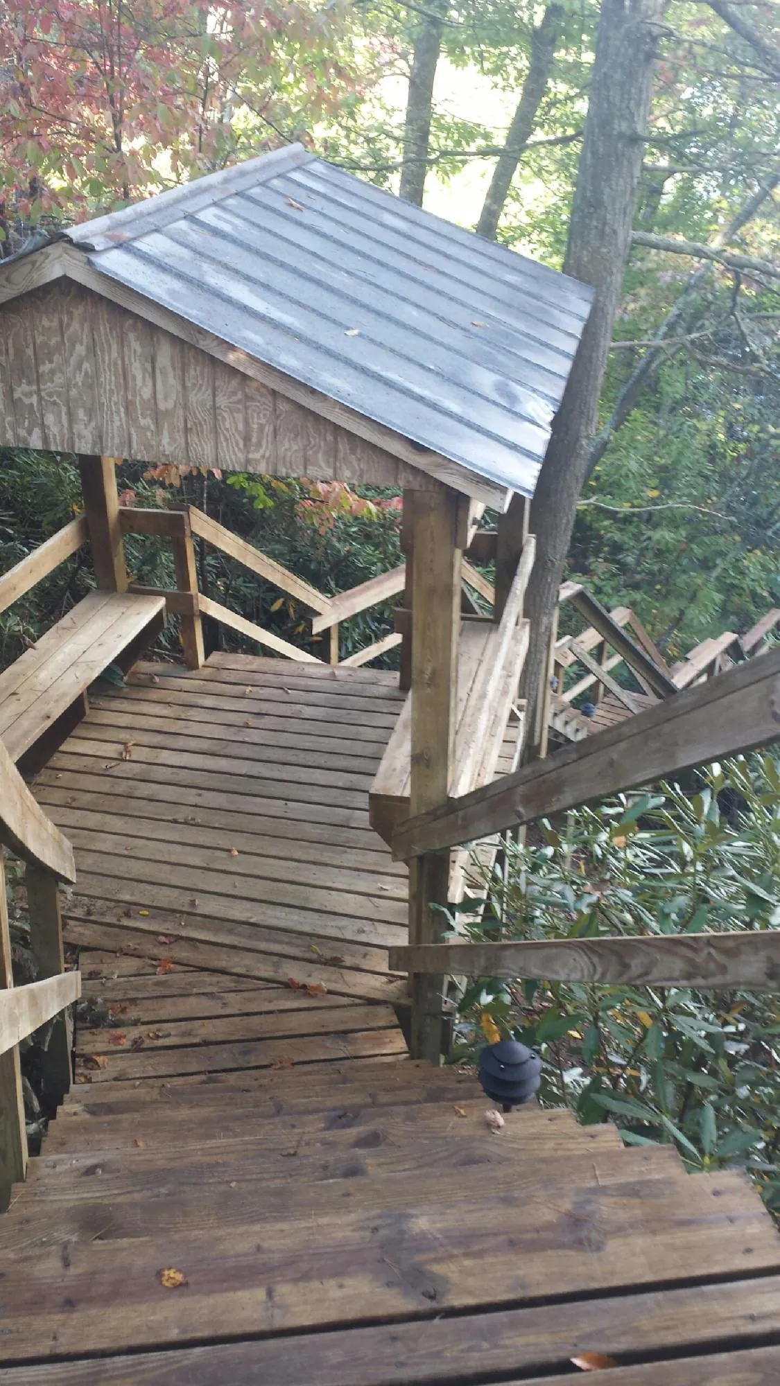 Metal roofed shelter over wooden steps on a wooded walkway — Skylight Repair & Installation work by our crew in Carversville