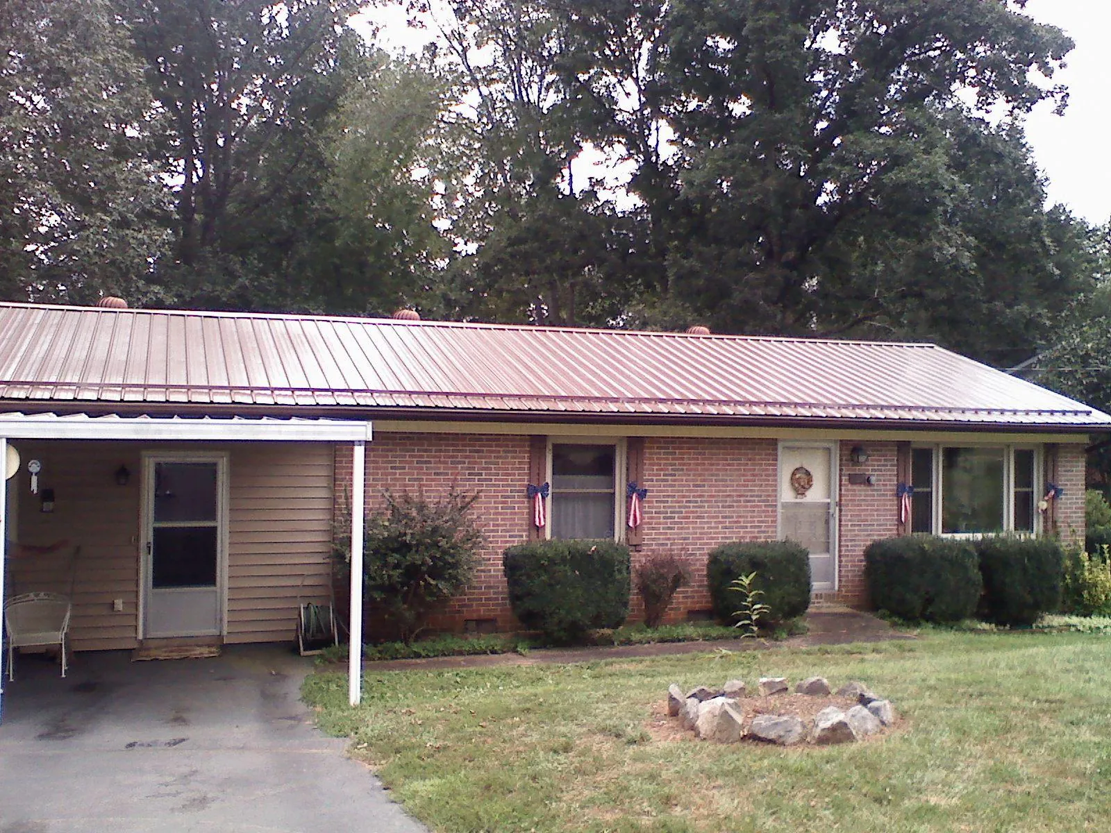 Bronze metal roof and carport on a brick ranch home — Roof Repair work by our crew in Carversville